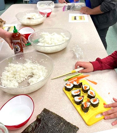 A chef from community and family services teaches a sushi-making class at Sticks and Stones