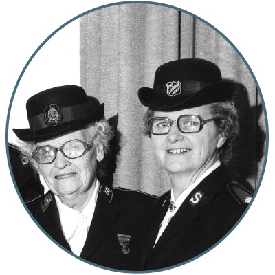 Two women wearing bowler hat-style bonnets