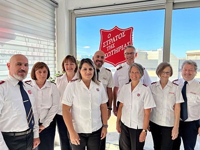 A group of people standing together with a Salvation Army shield in the background