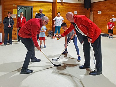 Adults and children play indoor hockey