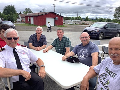 A group of men sitting around a table outside