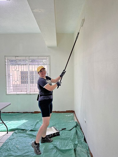 Photo of Captain Laura Van Schaick painting a wall