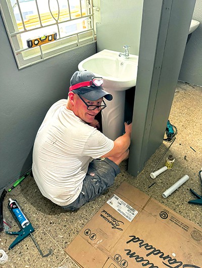 Photo of John Dunlop installing a sink