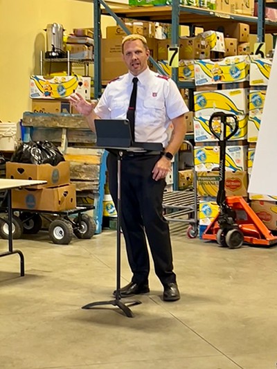 Lt Neil Thompson speaks behind a podium