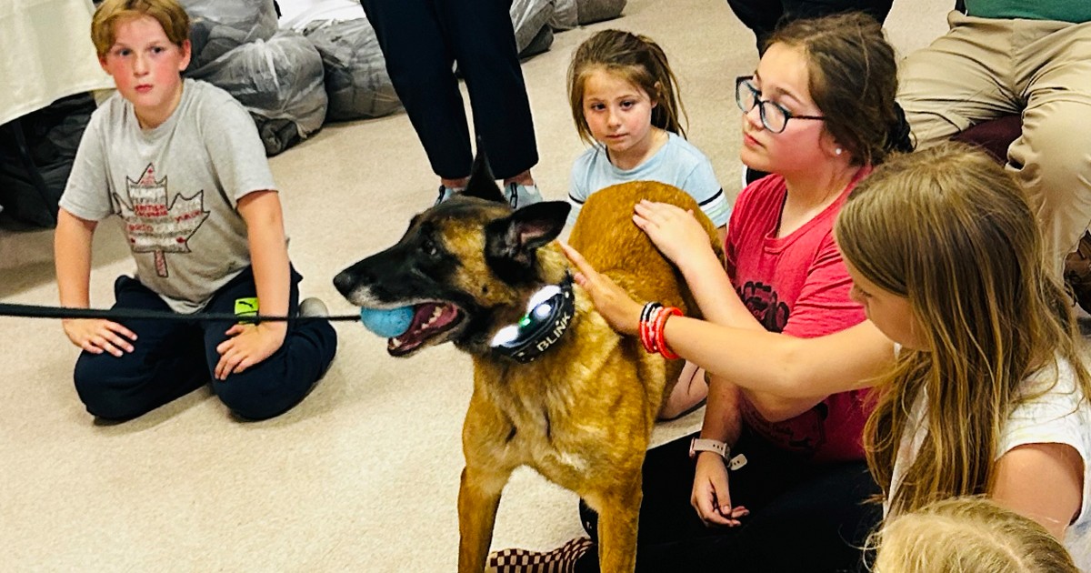 A police officer gives a presentation on community safety with his dog, Blink 