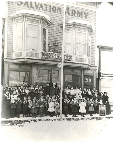 A large group of people standing outside a Salvation Army hall