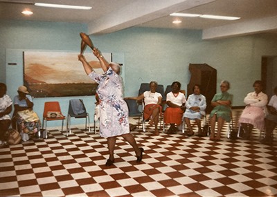 A woman swings a club in front of a group