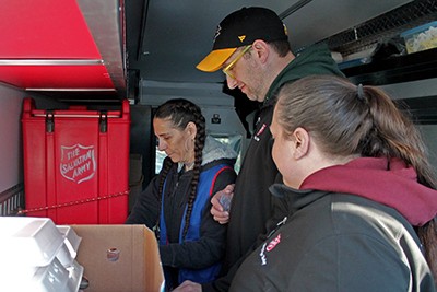 One man and two women serve in a Salvation Army food truck