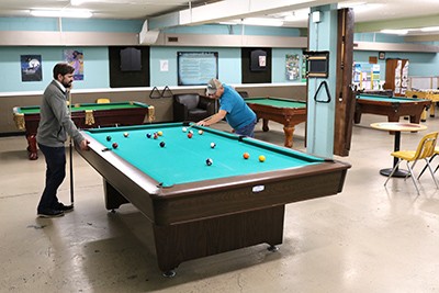 Lt Nathanael shoots a game of pool in the drop-in centre 