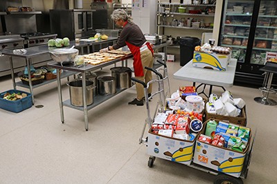 A volunteer prepares food in a kitchen