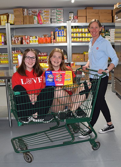 Marilyn vanDeursen gives a special guided tour of the Salvation Army food bank to Abigail and Kyra