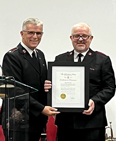 Lt-Col Morris presents Mjr Vaden with his retirement certificate during a Sunday morning service in Triton, N.L., in 2023