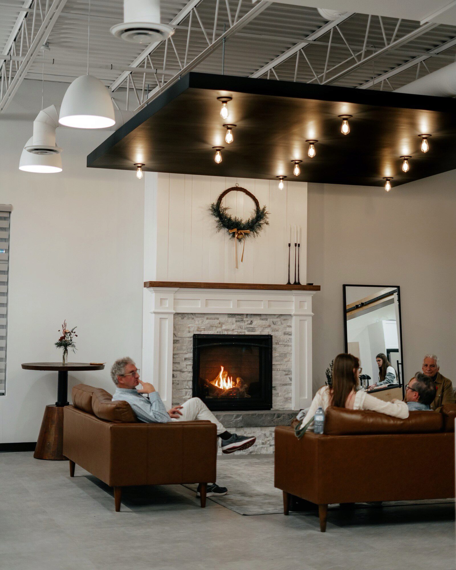 Congregants sit in front of a fireplace