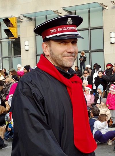 A smiling John Lam wearing a red scarf