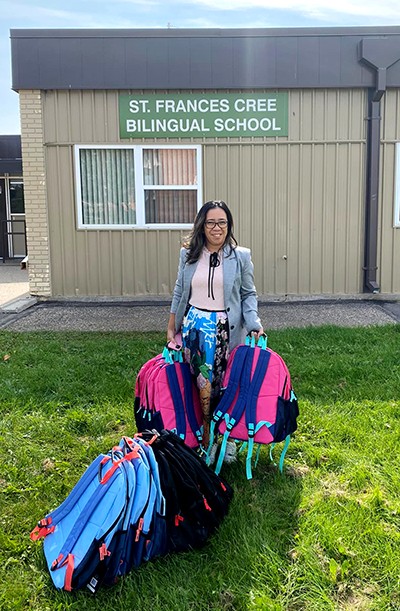Salvation Army employee holds children's backpacks