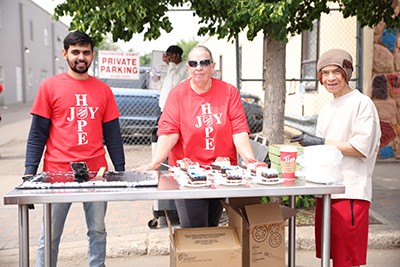 Volunteers serve an anniversary cake 