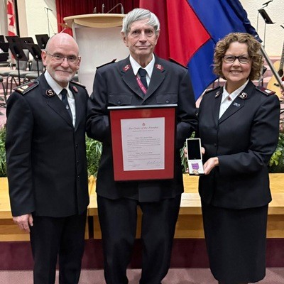 Man and woman present a man with an award