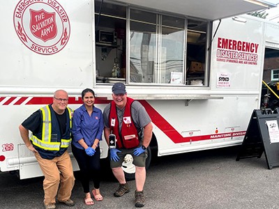 Kaur stands in front of EDS truck with other volunteers