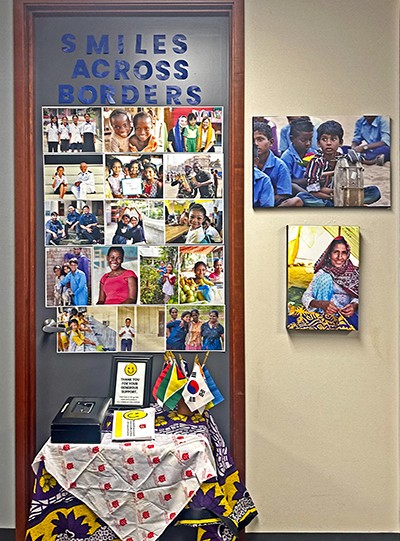 Guests are greeted by a display titled“Smiles Across Borders”—a joyful collection of portraits featuring individuals and families whose lives have been impacted by Army programs