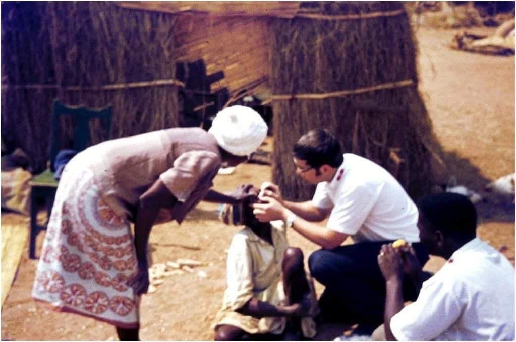 A doctor examines a woman while two others look on