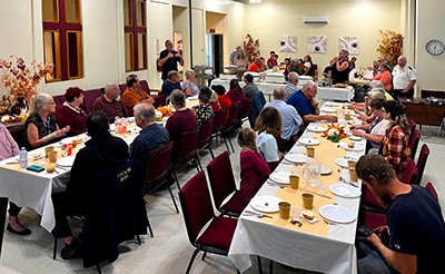 Church members eat together at dining tables