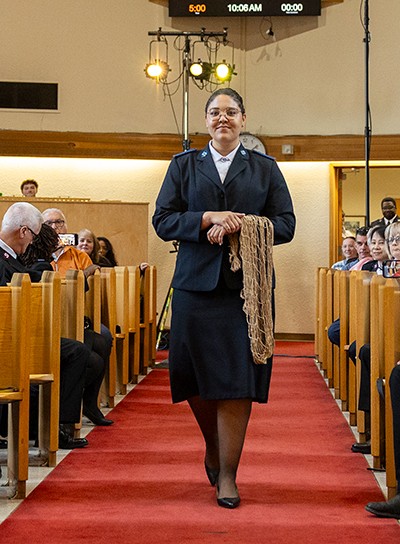 A woman carries a net down the aisle of a church