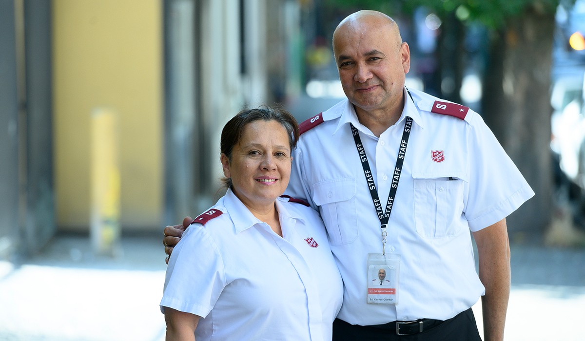 Two Salvation Army officers in white uniforms with a welcoming smile.