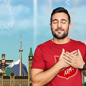 Image of a man wearing a red t-shirt with a Salvation Army logo on it and putting his hands on his chest