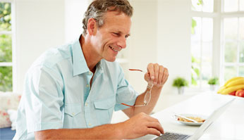 Image of man looking at laptop screen.