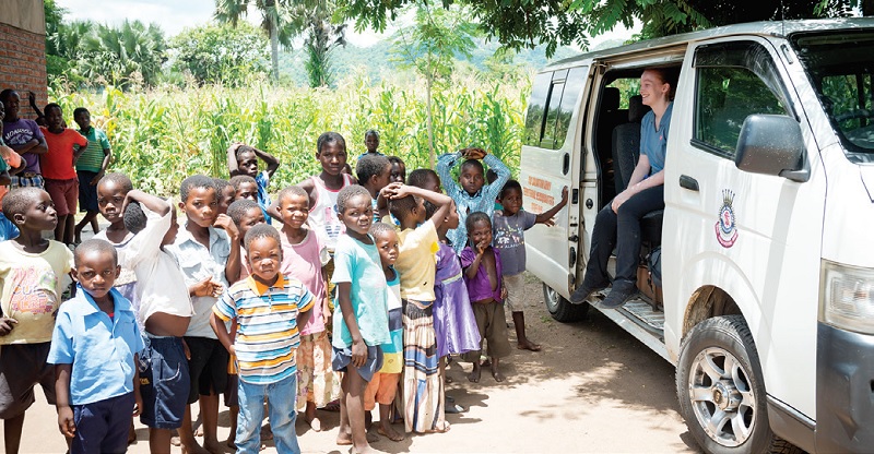 Ruth Hobbis (right) takes a break with local children in a Malawian village