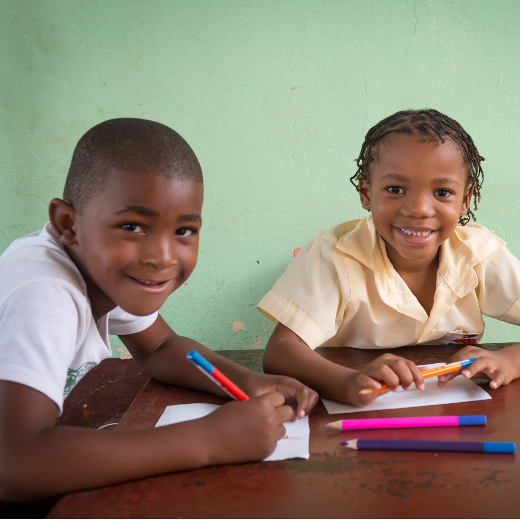 Photo of young male and female student from Mozambique doing school work in class